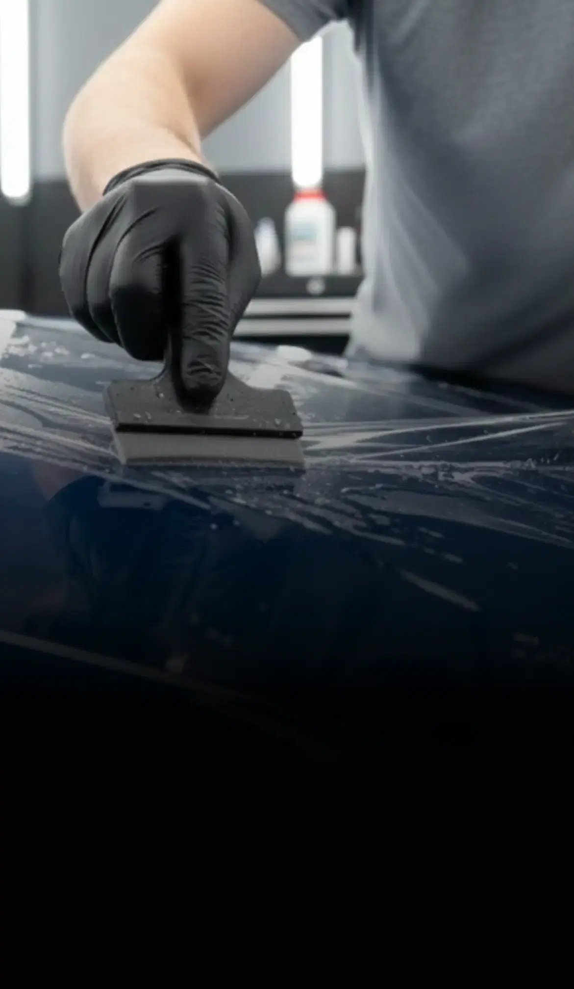 Installer wrapping a car in blue vehicle, highlighting Speed Shield USA's expertise in paint protection and vehicle wraps.